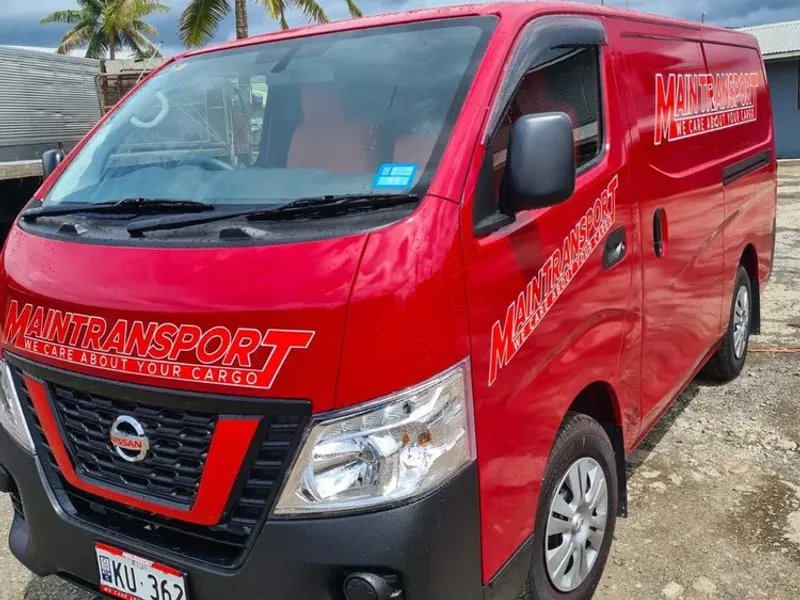 Red Main Transport Nissan delivery van with company signage, parked at the Suva depot